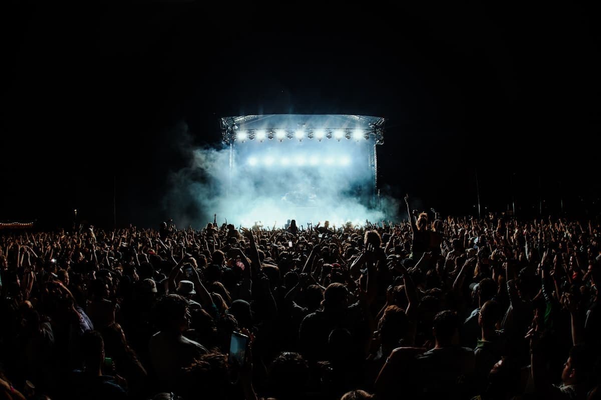 A crowd facing a brightly lit stage at night