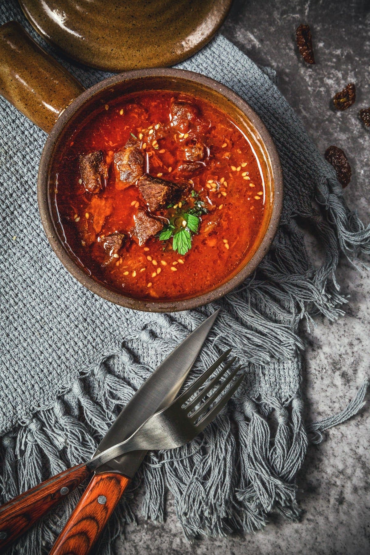 A bowl of red pepper stew with chunks of beef
